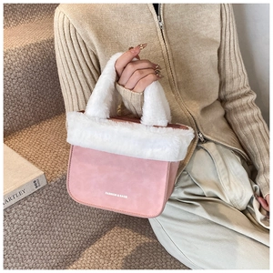Pink faux fur bucket bag with white trim shown in a stylish lifestyle setting on stairs