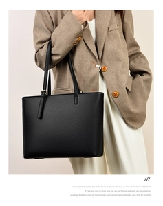 Close-up of black lychee grain leather tote bag with elegant gold metal hardware details