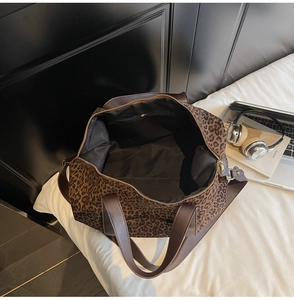 Vue de dessus du grand sac cabas imprimé léopard avec poche zippée et accessoires de voyage