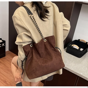 Detailed side view of deep coffee suede tote bag with drawstring and gold chain strap