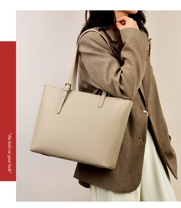 Close-up of beige lychee leather tote bag with adjustable metal buckle on shoulder strap