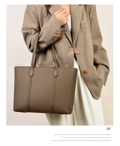 Gros plan du cabas en cuir marron texturé porté par un mannequin pour le style bureau