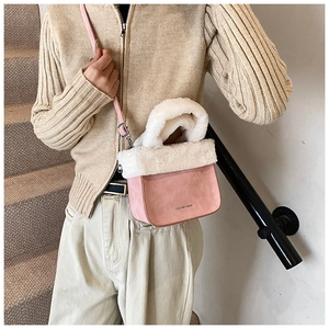 Pink suede bucket bag with white faux fur trim shown on model wearing a knit cardigan