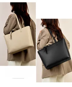 Detailed view of cream and black pebbled tote bags with adjustable shoulder straps