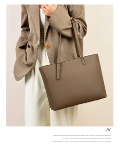 Detail of dark brown lychee leather tote bag with adjustable strap on a model