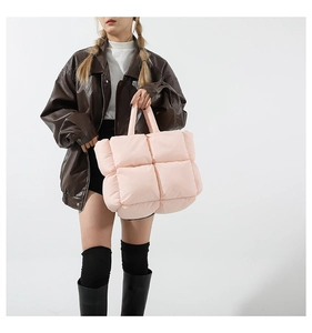 Sac fourre-tout matelassé rose au design rembourré porté par un mannequin en mode casual