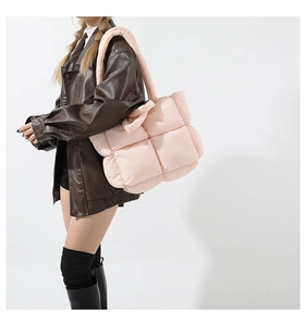 Détail d'un sac cabas matelassé rose avec texture rembourrée douce et bandoulière large