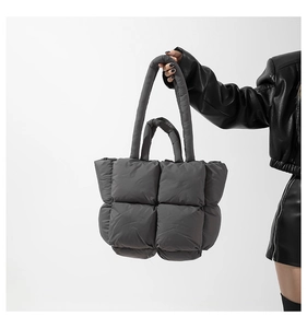 Gros plan du sac cabas matelassé gris foncé avec tissage à carreaux et doubles anses
