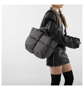 Détail d'un sac à bandoulière matelassé gris foncé en nylon brillant avec texture rembourrée