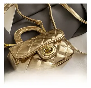 Close-up of golden quilted mini bag featuring a metal twist lock and luxury chain strap