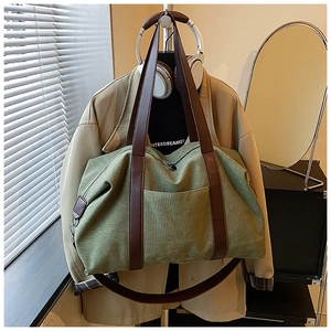 Detail of olive green canvas tote bag with brown PU handles and adjustable shoulder strap