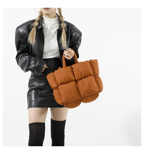 Détail du sac bandoulière matelassé orange avec carreaux rembourrés et poignée supérieure
