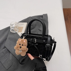 Sac à main vintage motif léopard avec breloque peluche sur fond de costume gris chic