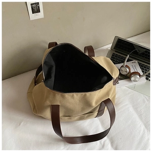 Top view of spacious canvas tote bag with brown leather handles and inner lining