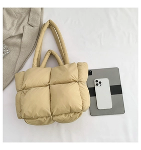 Vue de dessus d'un sac à main matelassé en nylon avec doubles anses et accessoires