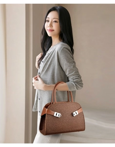Détails du cuir tressé marron et de la boucle en métal argenté du sac à main