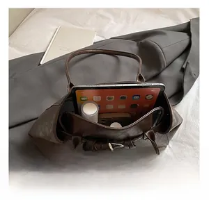 Top view of brown leather tote showing spacious interior with tablet and daily essentials