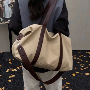 Minimalist beige canvas tote bag with brown leather straps shown in an outdoor lifestyle view
