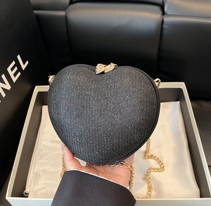 Close-up of heart-shaped crossbody bag with black glitter texture and gold chain