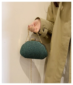 Dettaglio borsa da sera glitter verde scuro con catena dorata e trama in tessuto pieghettato