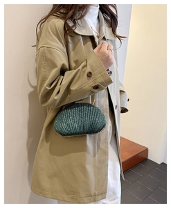 Dettaglio pochette a conchiglia smeraldo con paillettes e tracolla a catena d'oro