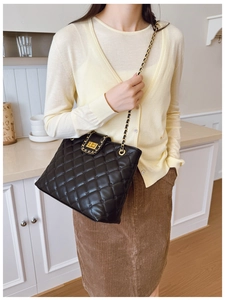 Photo lifestyle d'un sac bandoulière noir matelassé avec chaîne dorée sur un mannequin