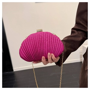 Dettaglio della borsa a conchiglia con paillettes rosa e catena dorata e pieghe chic
