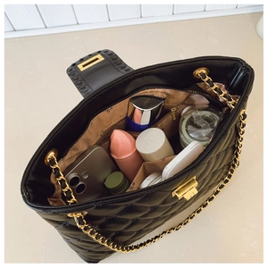 Vue de dessus de l'intérieur du sac matelassé noir montrant sa grande capacité