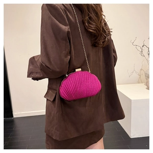 Dettaglio pochette fucsia a forma di conchiglia con glitter e tracolla a catena d'oro