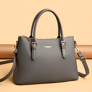 Detail of grey textured leather tote with gold-tone hardware and adjustable strap