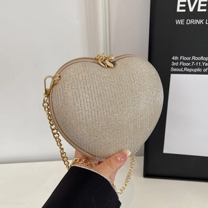 Elegant champagne gold heart-shaped evening bag with glitter texture and chain strap
