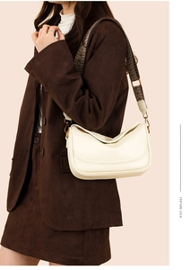 Détail du sac bandoulière en cuir crème avec large sangle jacquard à motifs sur un mannequin