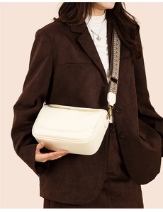 Détail du sac bandoulière demi-lune crème avec une sangle tissée au style vintage