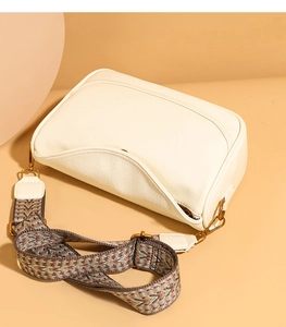 Détail du sac bandoulière blanc crème avec une large sangle tissée aux motifs géométriques