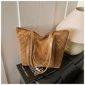 Detail of brown quilted tote bag with silver rivets and elegant diamond stitching
