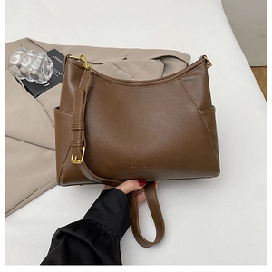 Close-up of dark brown leather handbag featuring gold hardware and logo detail