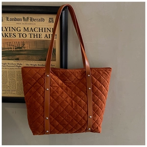 Detail of caramel quilted tote bag featuring soft suede texture and leather straps