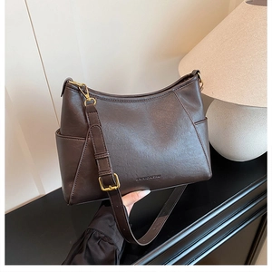 Close-up of matte dark brown leather hobo bag with side pockets and shoulder strap