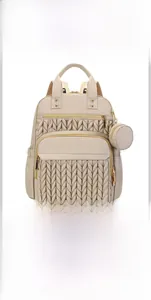 Detail view of beige quilted diaper bag showing multi-compartment storage for baby essentials