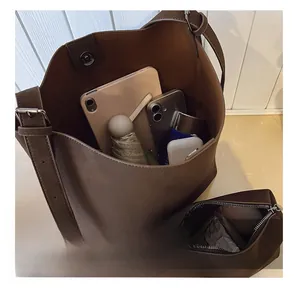 Internal capacity of dark brown leather bucket bag showing tablet and daily essentials