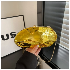 Detailed view of a gold shell-shaped evening clutch bag with wavy metallic texture