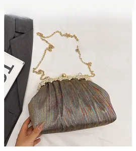 Detailed macro of iridescent metallic party bag with pleated texture and crystal clasp