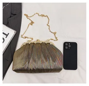 Detail of gold pleated evening clutch with rhinestone metal frame and chain strap