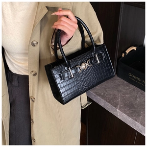 Detailed view of black crocodile pattern leather handbag with silver metal ring buckle