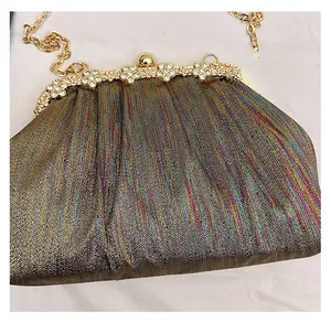 Detail of glitter gradient clutch with floral rhinestone clasp and gold chain strap