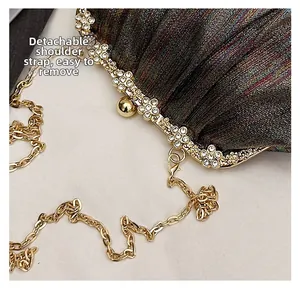 Detail of evening clutch featuring rhinestone gold frame and detachable chain strap