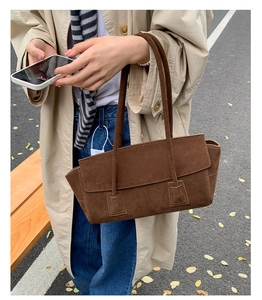 Sac à bandoulière en daim marron givré porté dans un style urbain automnal chic