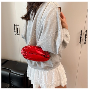 Detailed view of glossy red mirror acrylic clutch with fine gold chain strap