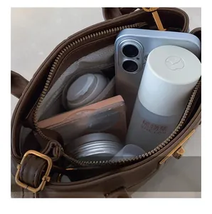 Internal view of dark brown leather handbag showing large capacity and zippered pocket