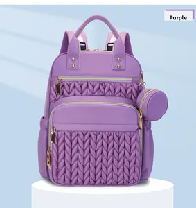 Detailed macro view of purple quilted backpack with gold zippers and matching coin purse